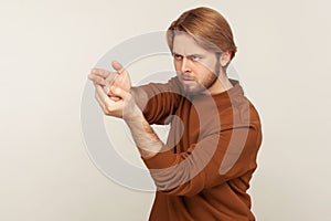 Aimed shot. Portrait of concentrated focused bearded man pointing finger gun gesture to target, threatening to kill