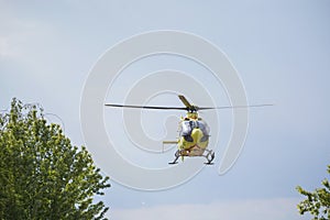 The air ambulance, service arrives at the scene of an accident. Flying yellow medical ambulance helicopter.