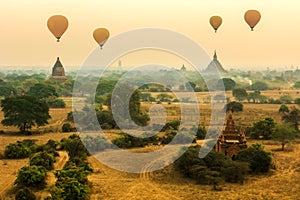 Air balloons flying over pagodas at misty morning in the plain o