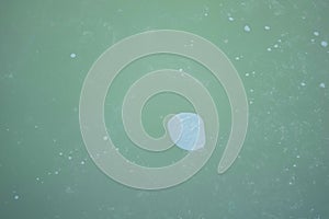 air bubble in a frozen lightgreen water from a lake