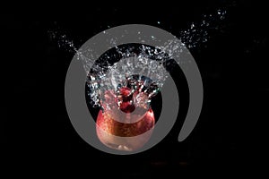 Air bubbles near a red Apple that has fallen into the water