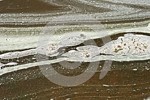 AIR BUBBLES IN SLUDGY FOAM PATTERNS AND CONTOURS IN THE THICK SLUDGE ON THE EDGE OF A MINERAL LAKE ON BOTTOM OF METEORITE CRATER