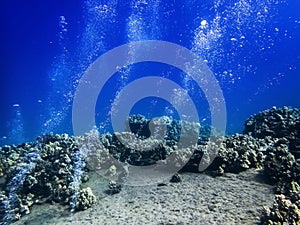 Air Bubbles from Underwater Shelf and Makes Stripes in Blue Sea over Reef