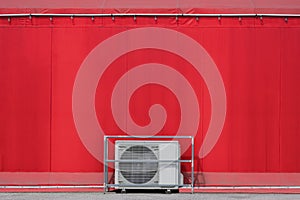 Air conditioner compressor on the floor with light blubs decoration outside of red event tent