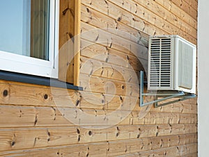 Air conditioner condenser on the wooden wall of boards.