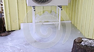 Air conditioner machine outdoors on rack on domestic home house yellow wall.