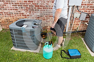 Air Conditioner maintenance with technician adding refrigerant
