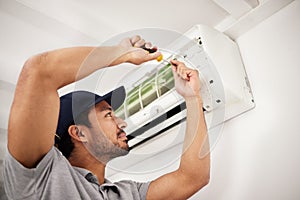 Air conditioner, man and electrical machine repair with person in a home with ac box. Maintenance, screwdriver and