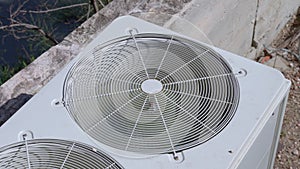 Air conditioner operates near street building on sunny day