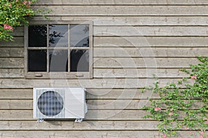 Air conditioner outdoor unit on a blue house with a window. 3d