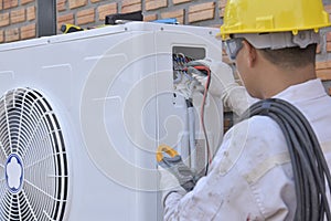 Air conditioner repairmen work on home unit photo