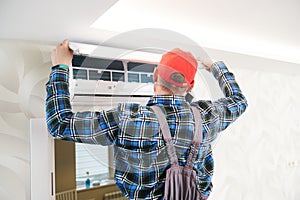 Air conditioner service. Worker at climatization system installation indoors