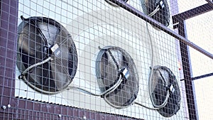 Air conditioner unit fan rotating. Industrial air conditioning system on the wall outdoors