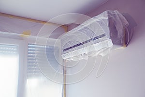 Air conditioner unit wrapped up in plastic sheet