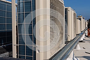 Air conditioner units HVAC on a roof of new industrial building with blue sky and clouds in the background