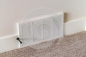 Air conditioner white plastic grille cover against wall and carpet floor