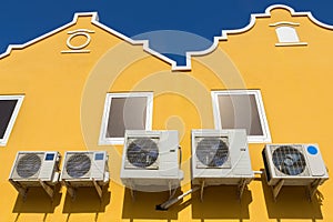 Air conditioners on yellow wall of houses