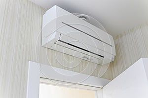 Air-conditioning, attached to wall, hanging over photo