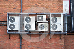 Air Conditioning condensers in cage hanging on wall