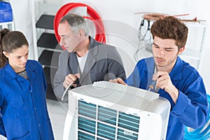 Air-conditioning repairman with apprentices