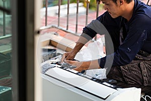Air conditioning technicians install new air conditioner, Technician service for repair and maintenance of air conditioners