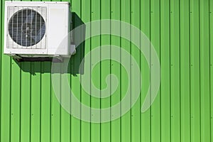 Air conditioning on wall. Cooling equipment. Green wall of industrial building