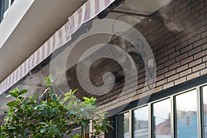 Air cooling system with water vapor and fans during heat and high temperature for street cafe