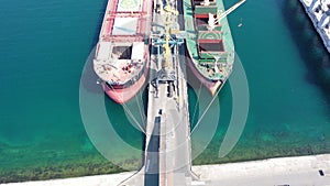 Air cranes in the port. Dry cargo ship at the marina. Cargo transportation. The vessel is loading.