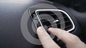 Air deflector and climate control inside a car. Action. Close up of car interior details with a hand touching deflector