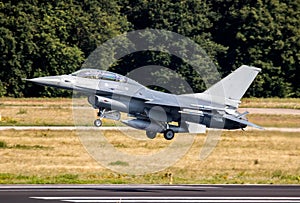 Air force fighter jet plane taking off from an airbase with full speed