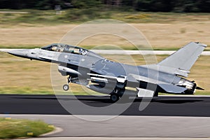 Air force fighter jet plane taking off from an airbase with full speed photo