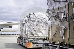 Air freight cargo on dolly trailer waiting to be loaded onto aircraft