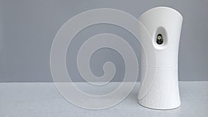 Air freshener automatic dispenser on grey background with copy space