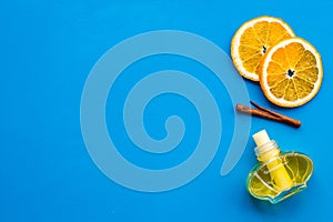Air freshener sticks with cinnamon and orange on blue background top view mockup
