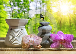 Air freshener with zen pebbles and orchid flowers on table.