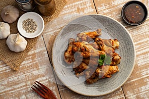 Air Fryer drummet chicken wing with garlic and pepper in a plate.