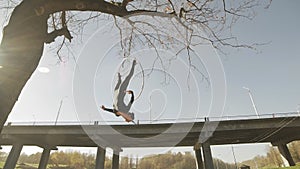 Air gymnastics brunette performs acrobatics tricks on aerial hoop
