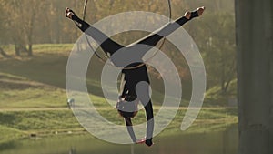 Air gymnastics woman performs acrobatics tricks on aerial hoop in slow motion