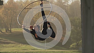 Air gymnastics woman performs acrobatics tricks on aerial hoop in slow motion