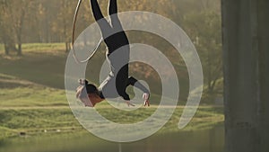 Air gymnastics woman performs acrobatics tricks on aerial hoop in slow motion