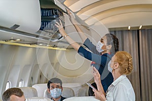 Air hostess helping senior passenger putting luggage into luggage cabin