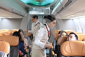 Air  hostess service on plane , flight attendant checking and closing cabin compartment in airplane