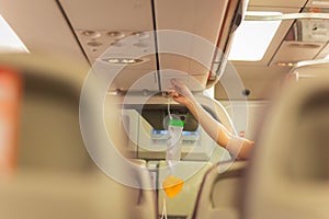 Air hostess is showing how to use oxygen mask before taking off.