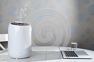 Air humidifier stay on table and spreading steam. Humidification of the dry air.