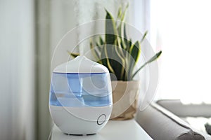 Air humidifier on table in living room. Space for text