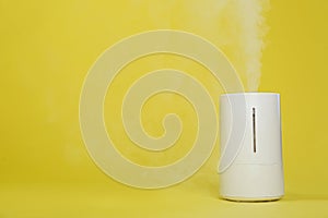 Air humidifier on yellow background. Space for text