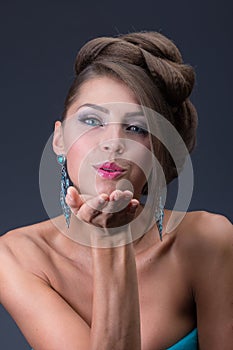 Air kiss from Woman wearing shiny blue earring