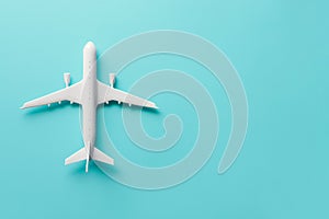 An air plane on blue background. Top view, white toy plane with copy space, minimal style. airliner, airplane, twin-engine jet