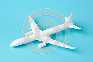 An air plane on blue background. Top view, white toy plane with copy space, minimal style. airliner, airplane, twin-engine jet