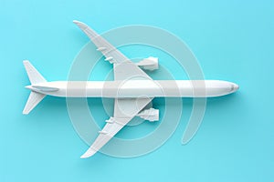 An air plane on blue background. Top view, white toy plane with copy space, minimal style. airliner, airplane, twin-engine jet